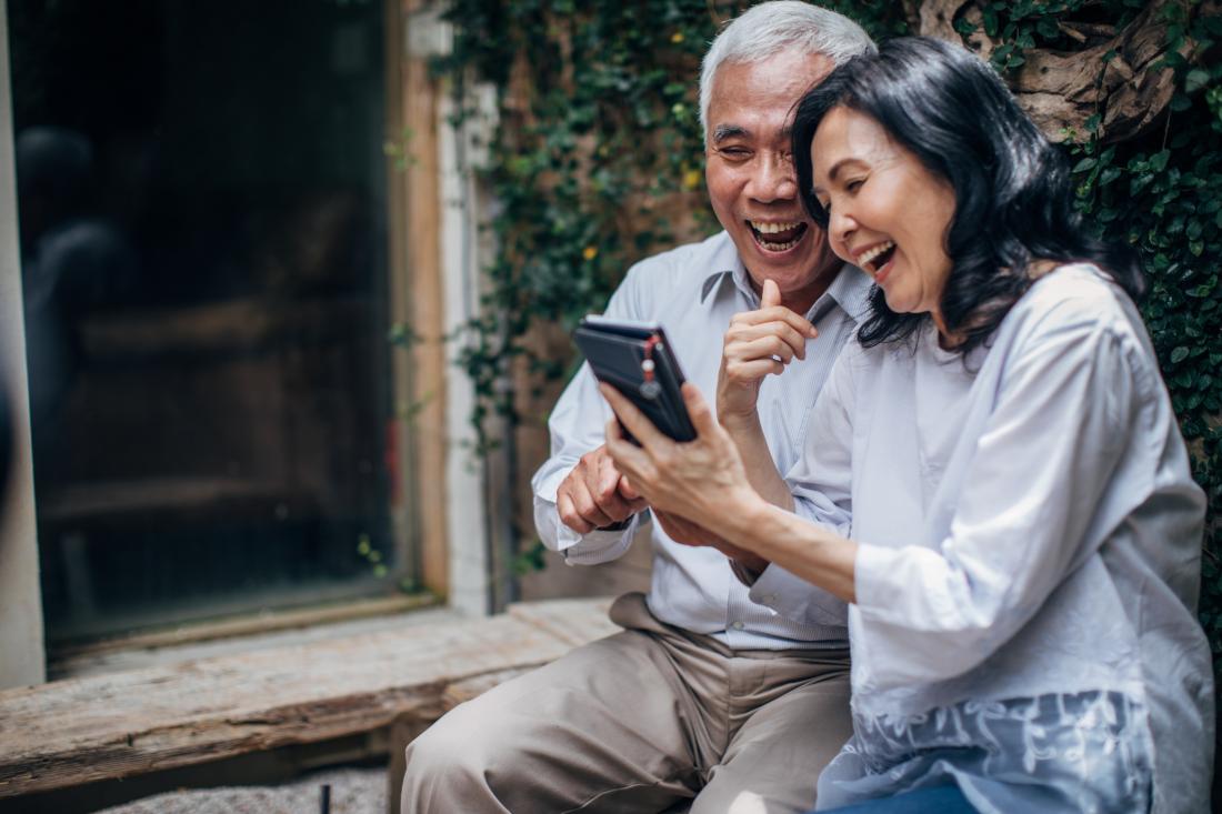 senior couple laughing at a mobile phone