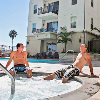 Two young men enjoy an outdoor hot tub.