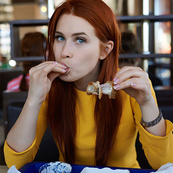 A woman eating a lot of food fast.