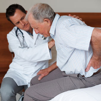 A doctor helping a senior patient in pain.