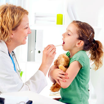 A doctor examines a child's throat.