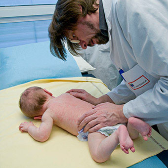 A doctor examines a baby's skin rash.