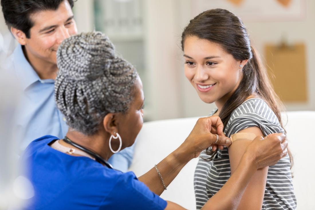 healthcare professional giving a young woman a vaccine