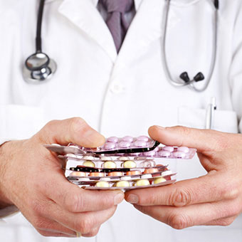 A doctor holds a variety of medications.