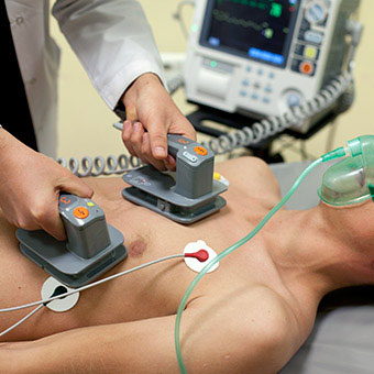 A doctor performs electrical cardioversion on a patient.