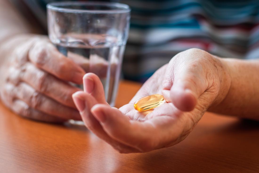 close up of woman taking fish oil capsules