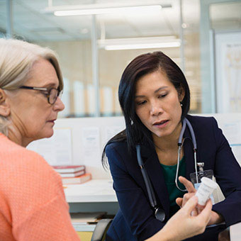 A doctor explains medication treatment to a patient with multiple sclerosis.
