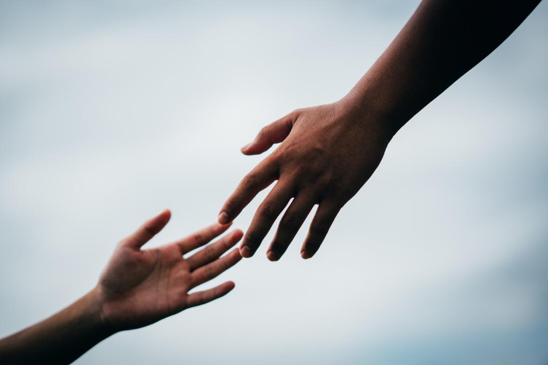 image of hand reaching to hold another hand