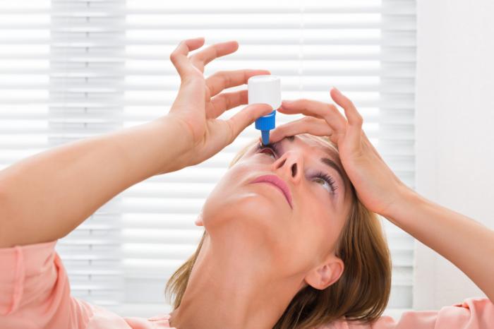 woman applying eye drops
