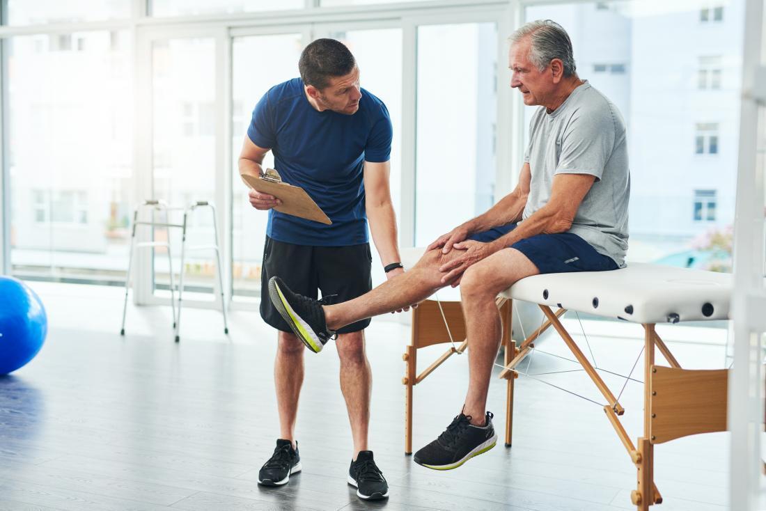 physiotherapist working with older man