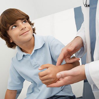 A doctor discussing a boy's wart treatment.