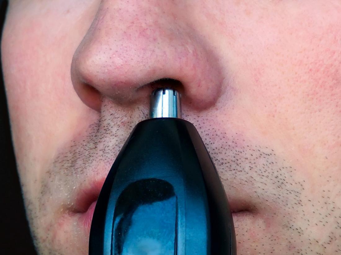 a man using a trimmer as a nose hair removal device