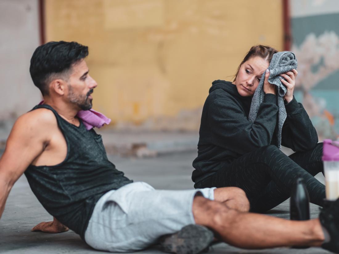 a man and woman resting after a workout. 