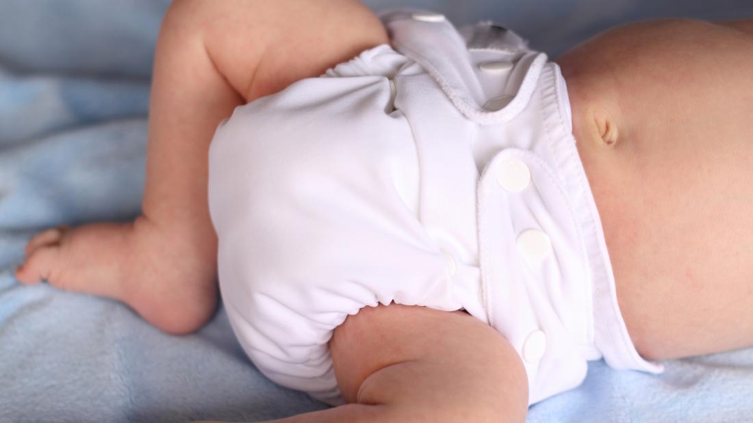 a baby wearing a cloth reusable diaper