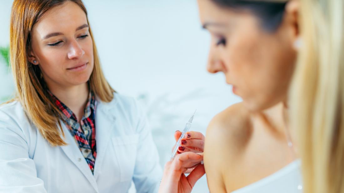 a woman about to receive a trigger point injection from a doctor 