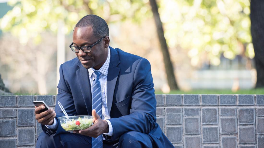 a man eating a salad for lunch as part of this 16:8 intermittent fasting diet