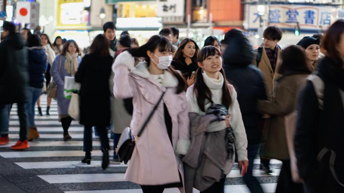 young woman wearing face mask on the street