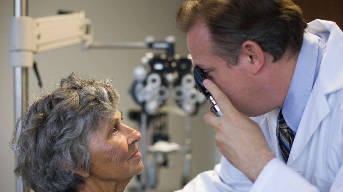 a doctor checking a persons eyes for any conditions related to Crohn's disease